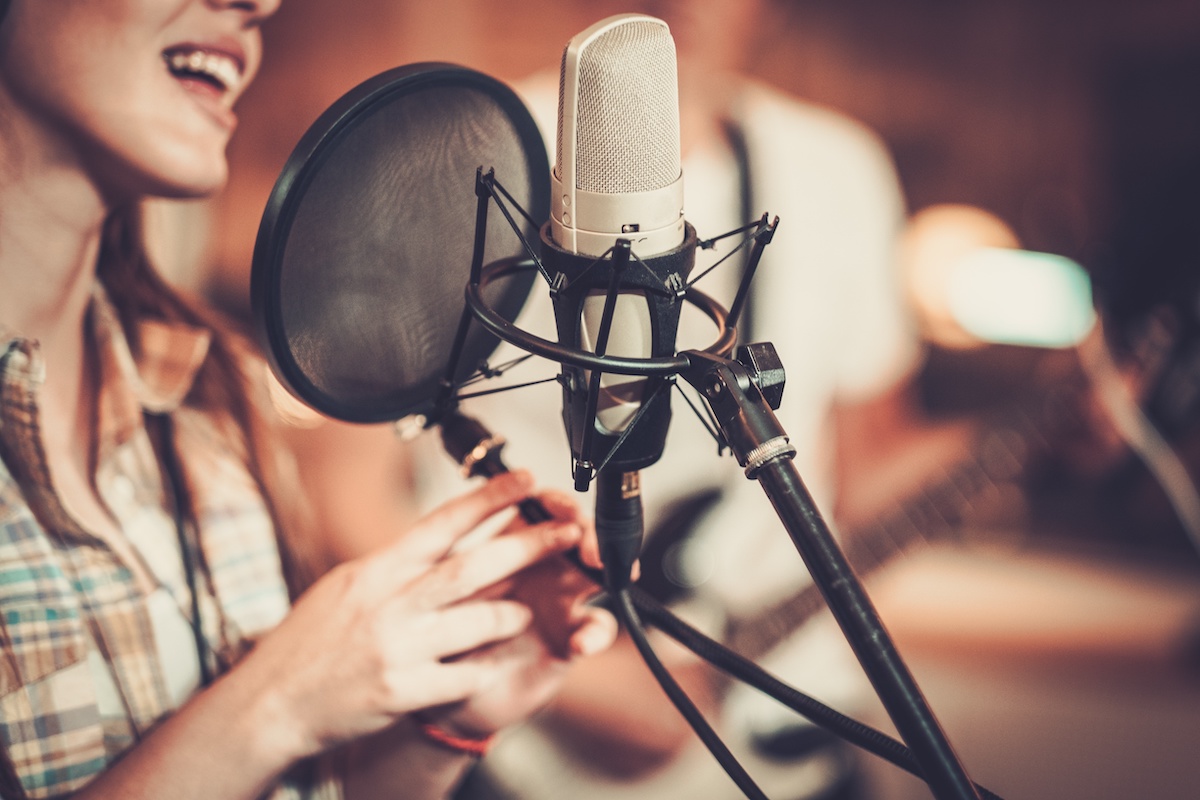 image cover: A women sign on the microphone